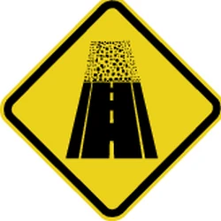 Warning for an unpaved road surface.