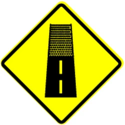 Warning for an unpaved road surface.